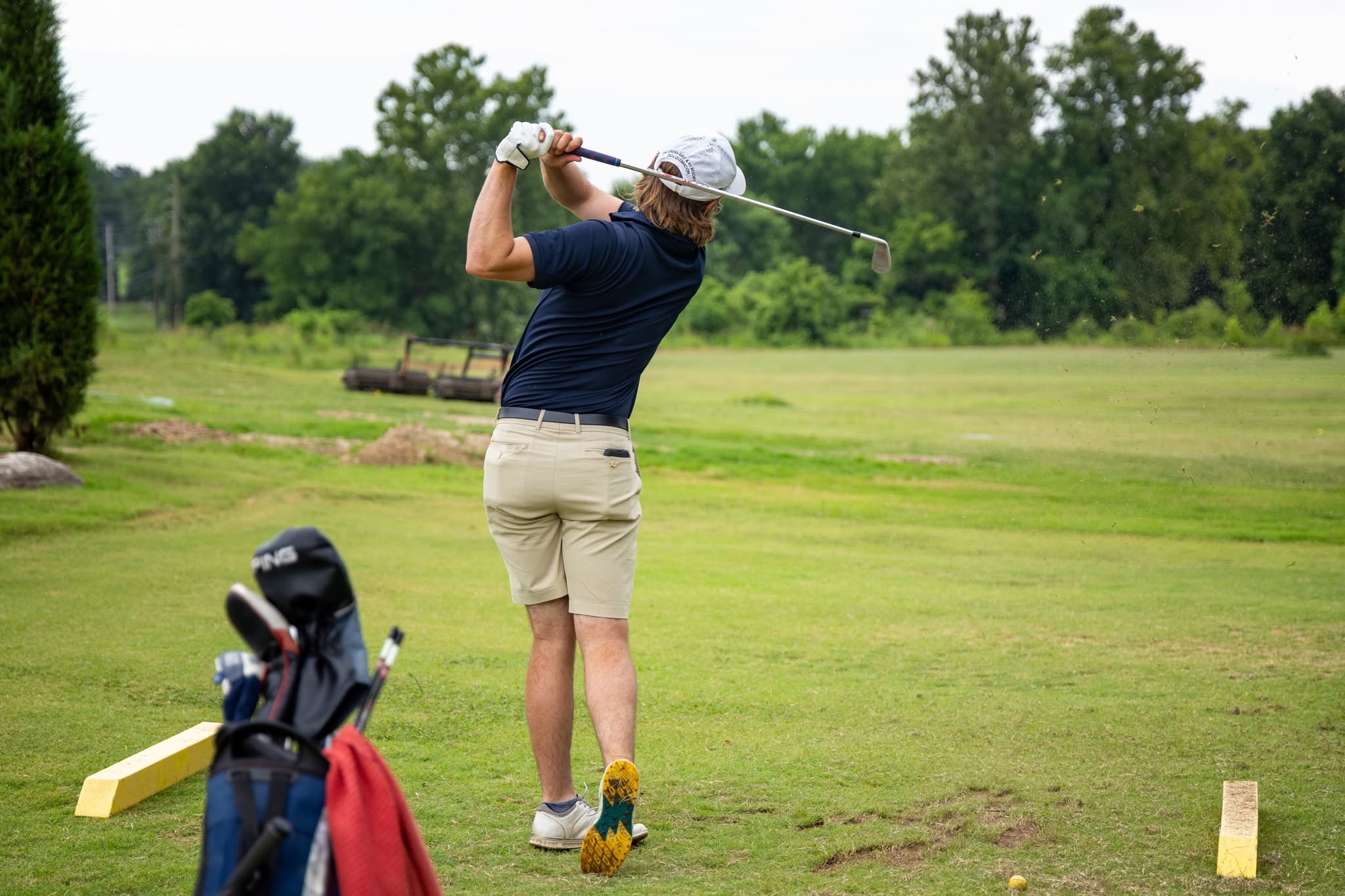 A golfer at the top of an iron swing out on the championship course at The Creeks