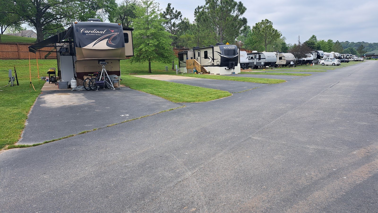 A row of paved big-rig RV sites in summer at The Creeks Golf & RV Resort